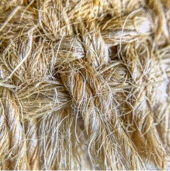 Imagen muy cercana de la urdimbre de una alfombra de color beige