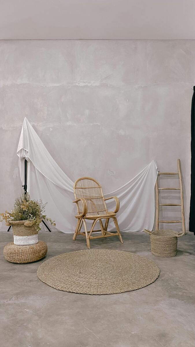 Alfombras de Fibra Vegetal de diferentes formas a chair and a basket in front of a wall